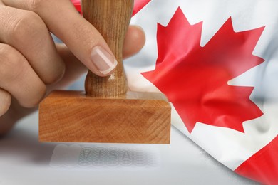 Image of Double exposure of woman stamping visa document and Canada flag, closeup