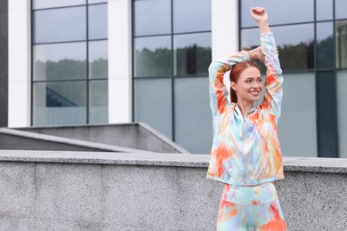 Photo of Beautiful woman in gym clothes doing exercises on street, space for text