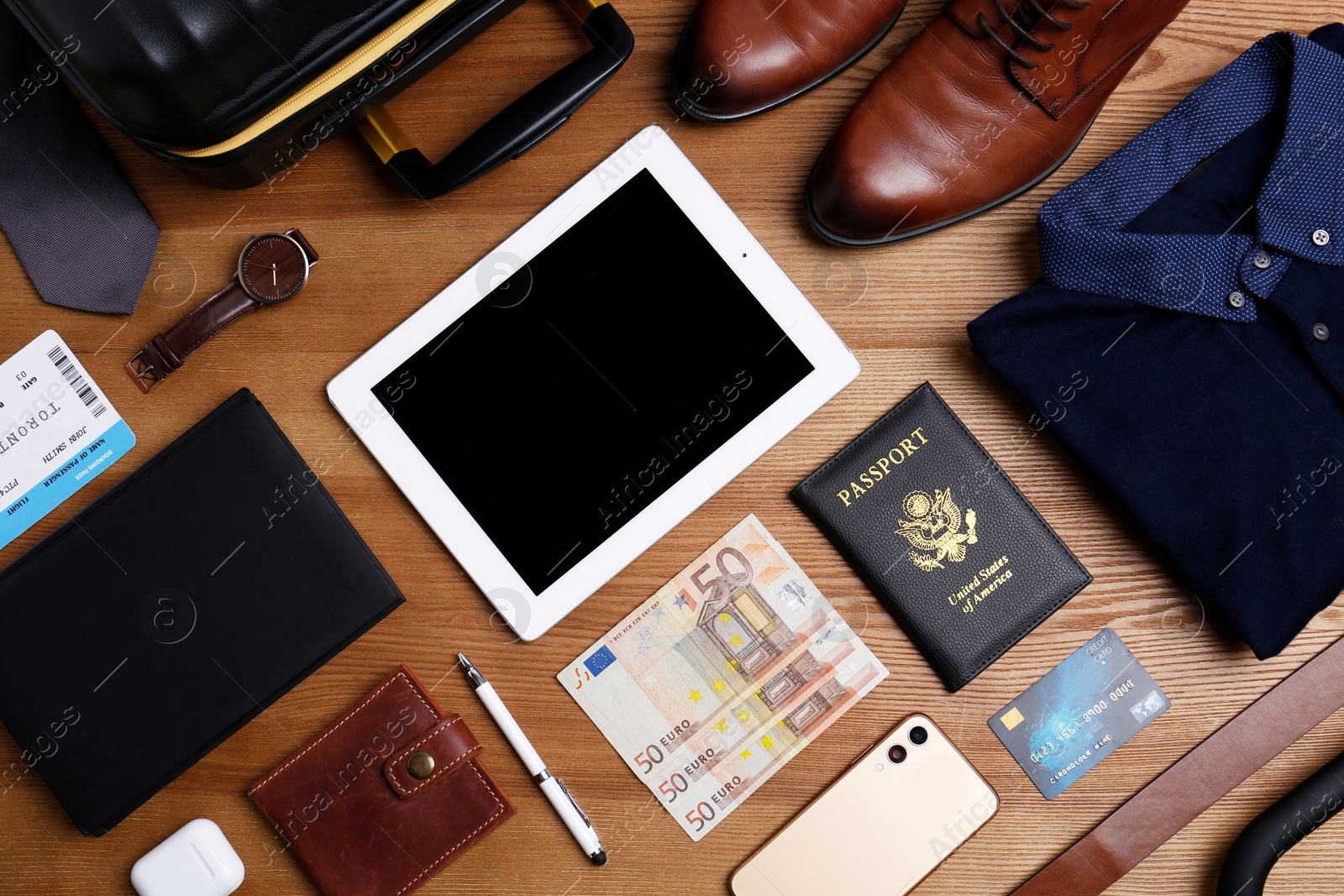 Photo of Business trip stuff on wooden surface, flat lay