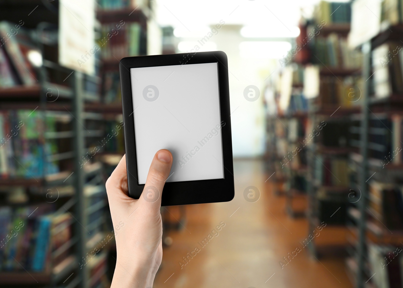 Image of Woman holding e-book reader in library, closeup