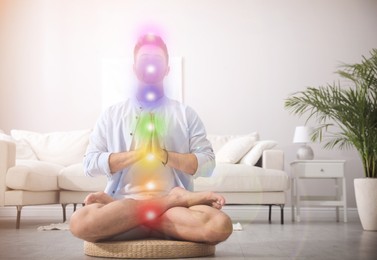 Young man meditating on straw cushion at home. Scheme of seven chakras, illustration