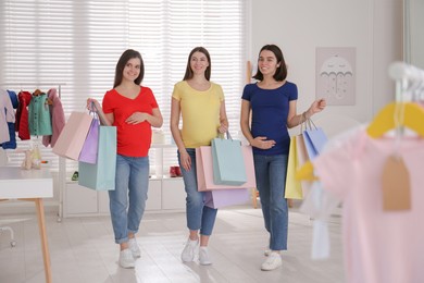 Photo of Happy pregnant women with shopping bags in store