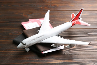 Photo of Toy airplane and passports with tickets on wooden background