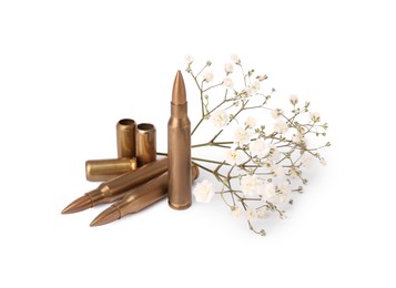 Photo of Bullets, cartridge cases and beautiful gypsophila flowers isolated on white