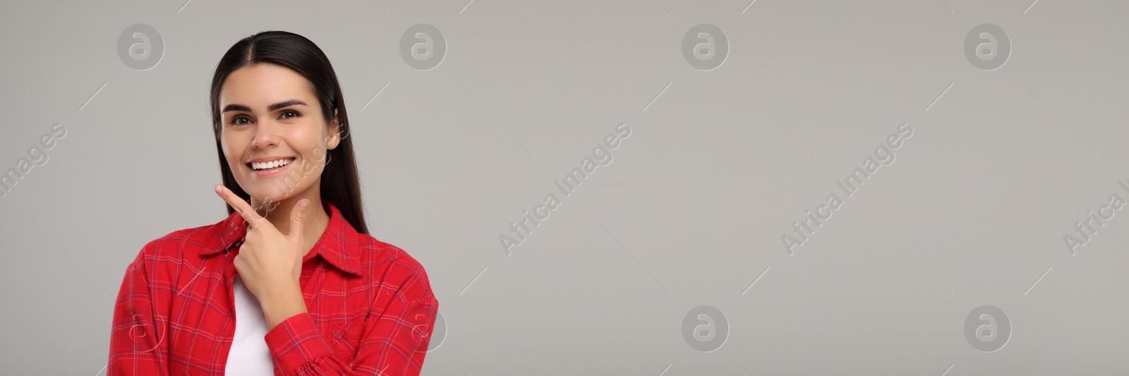 Image of Woman with clean teeth smiling on grey background, space for text. Banner design