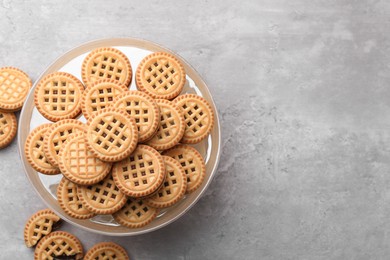 Tasty sandwich cookies with cream on grey table, flat lay. Space for text