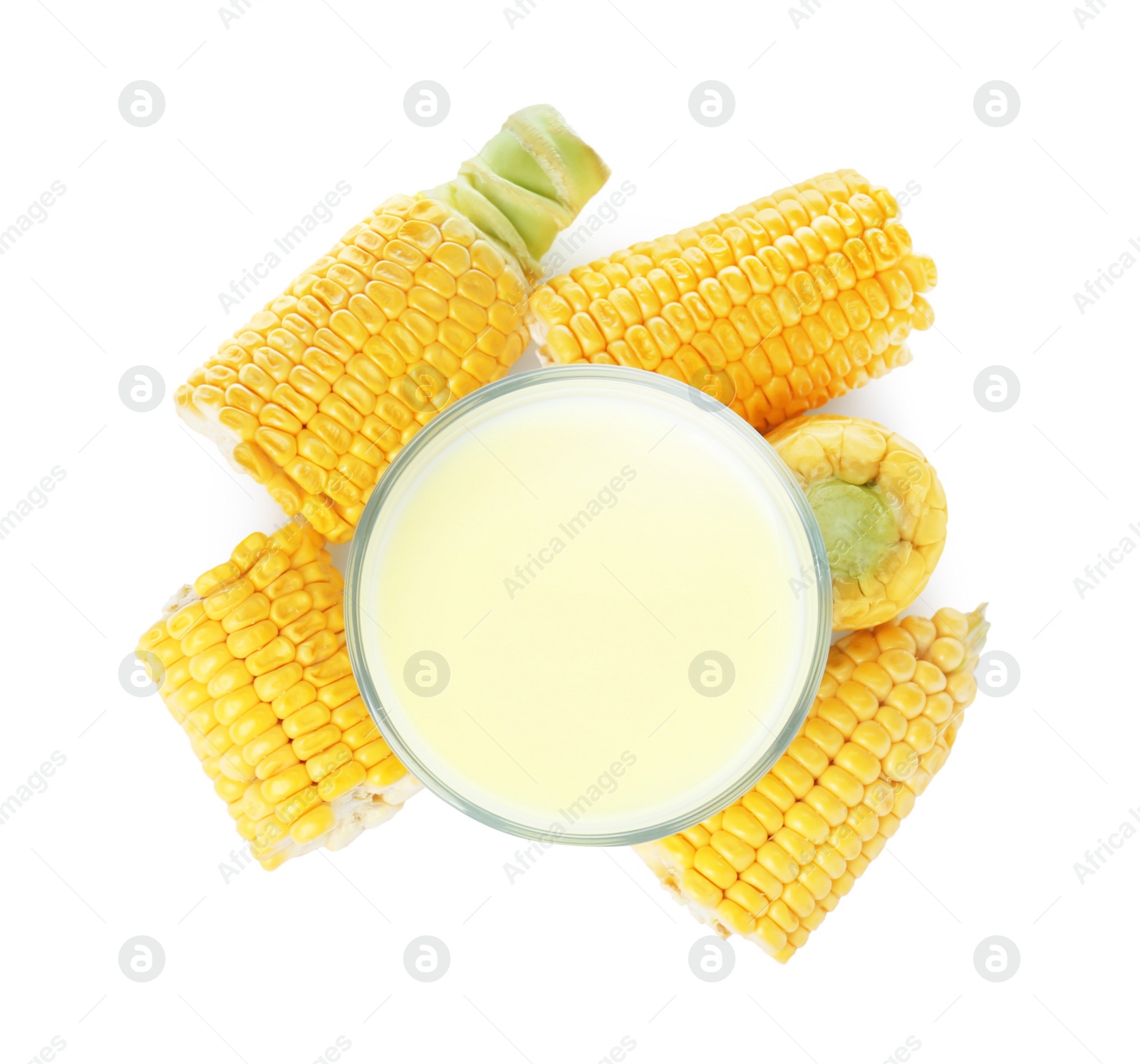 Photo of Tasty fresh corn milk in glass and cobs on white background, top view