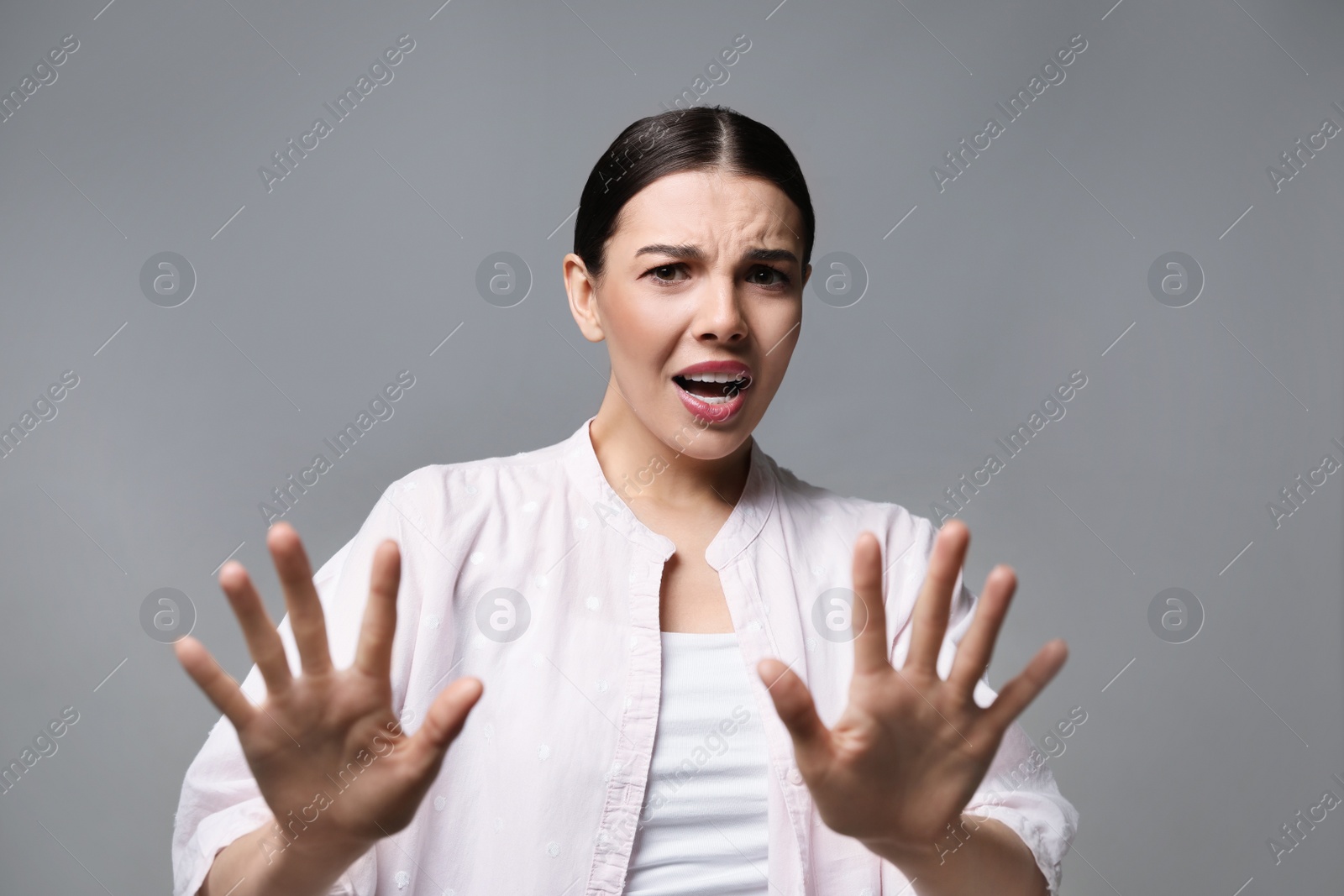 Photo of Young woman feeling fear on grey background