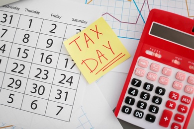 Flat lay composition with calendar and calculator on table. Tax day