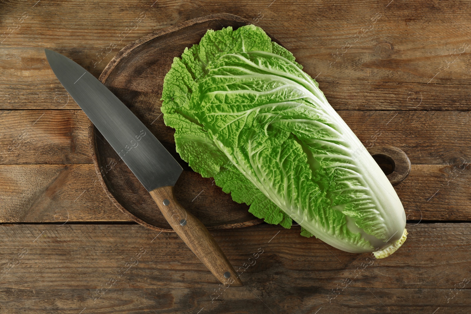 Photo of Fresh ripe Chinese cabbage and knife on wooden table, top view
