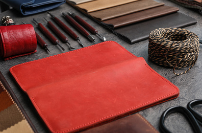 Photo of Leather samples and craftsman tools on grey stone background