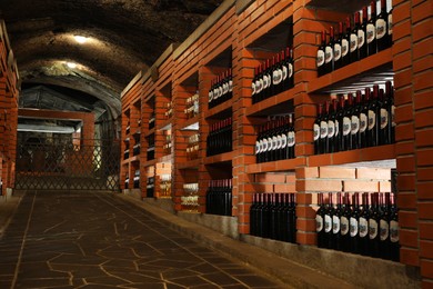 Photo of Beregove, Ukraine - June 23, 2023: Many bottles of alcohol drinks on shelves in cellar