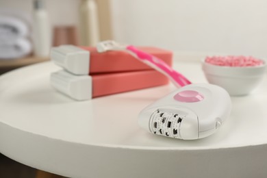 Set of epilation products on white table indoors