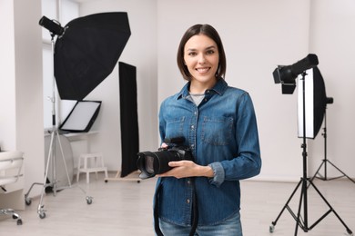 Professional photographer with camera in modern photo studio