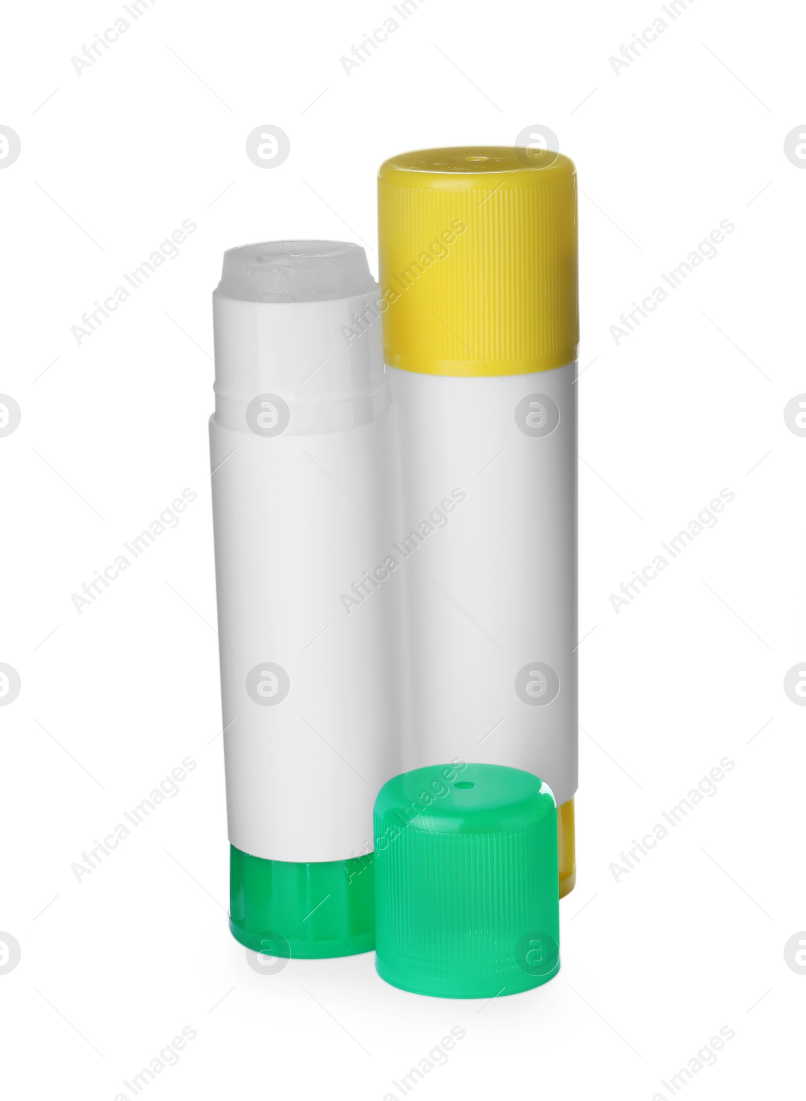 Photo of Different glue sticks and cap on white background