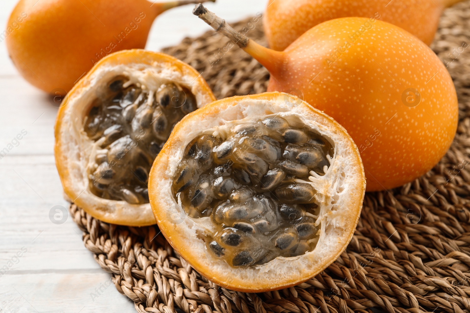 Photo of Delicious ripe granadillas on white wooden table, closeup