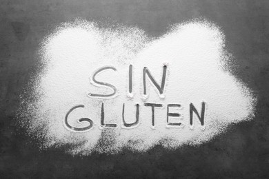Photo of Words Sin gluten written with flour on grey background, top view