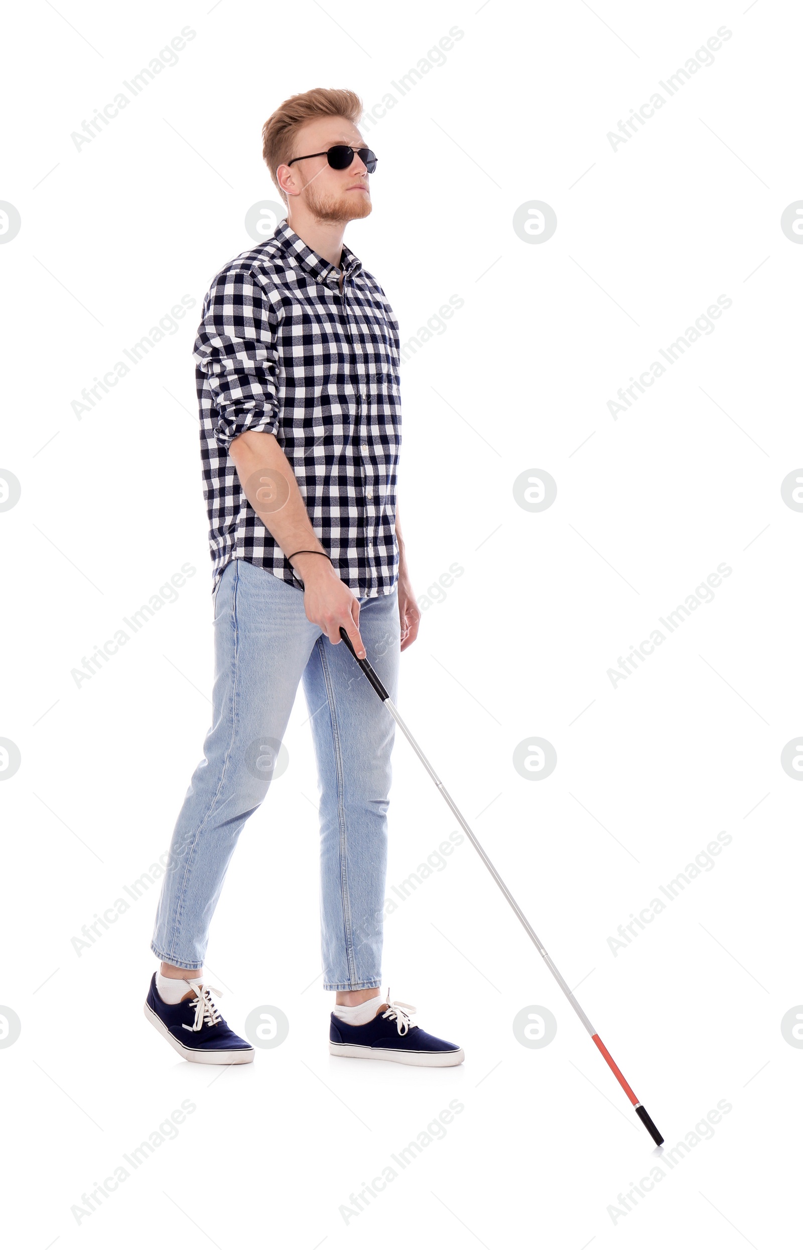 Photo of Young blind person with long cane walking on white background
