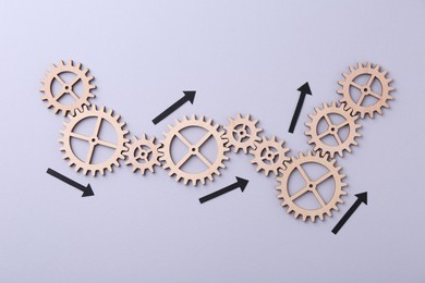 Photo of Business process organization and optimization. Scheme with wooden figures and arrows on lilac background, top view