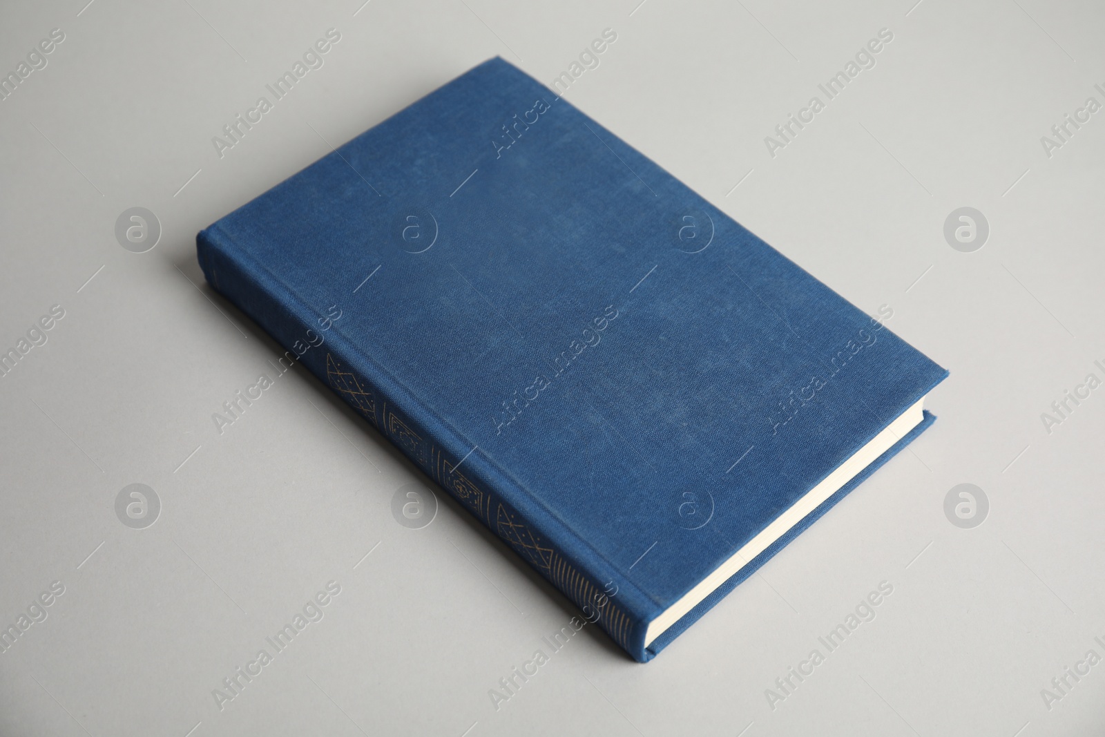 Photo of Hardcover book on light grey background. Space for design