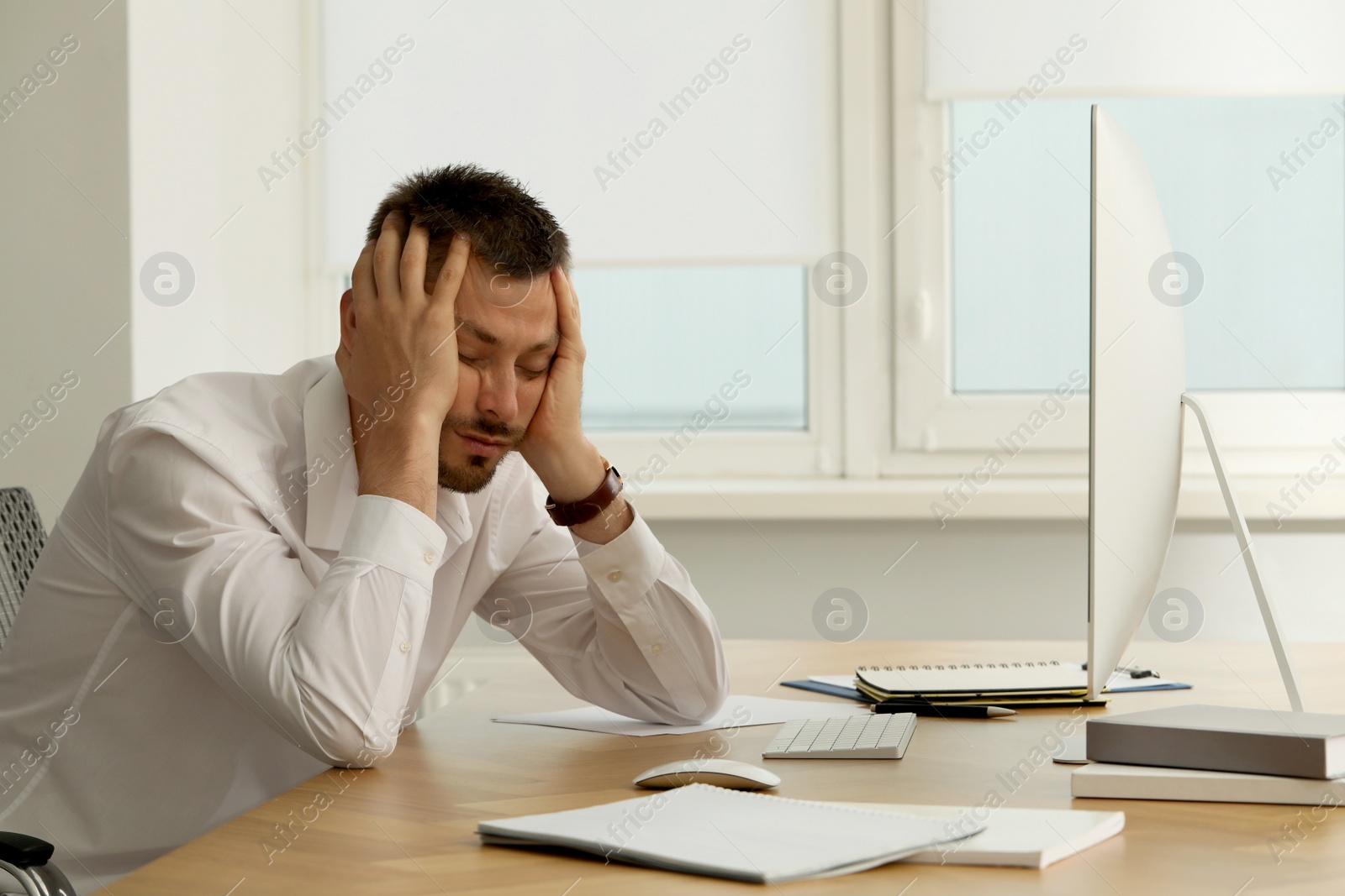 Photo of Sleepy man snoozing at workplace in office