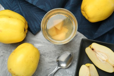 Photo of Delicious quince drink and fresh fruits on grey table, flat lay