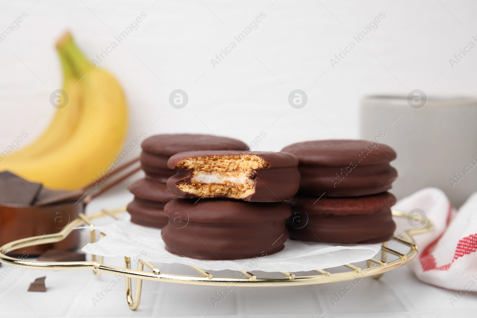 Photo of Tasty banana choco pies on white table, closeup