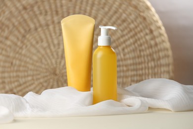 Photo of Bottle and tube of face cleansing products on beige table