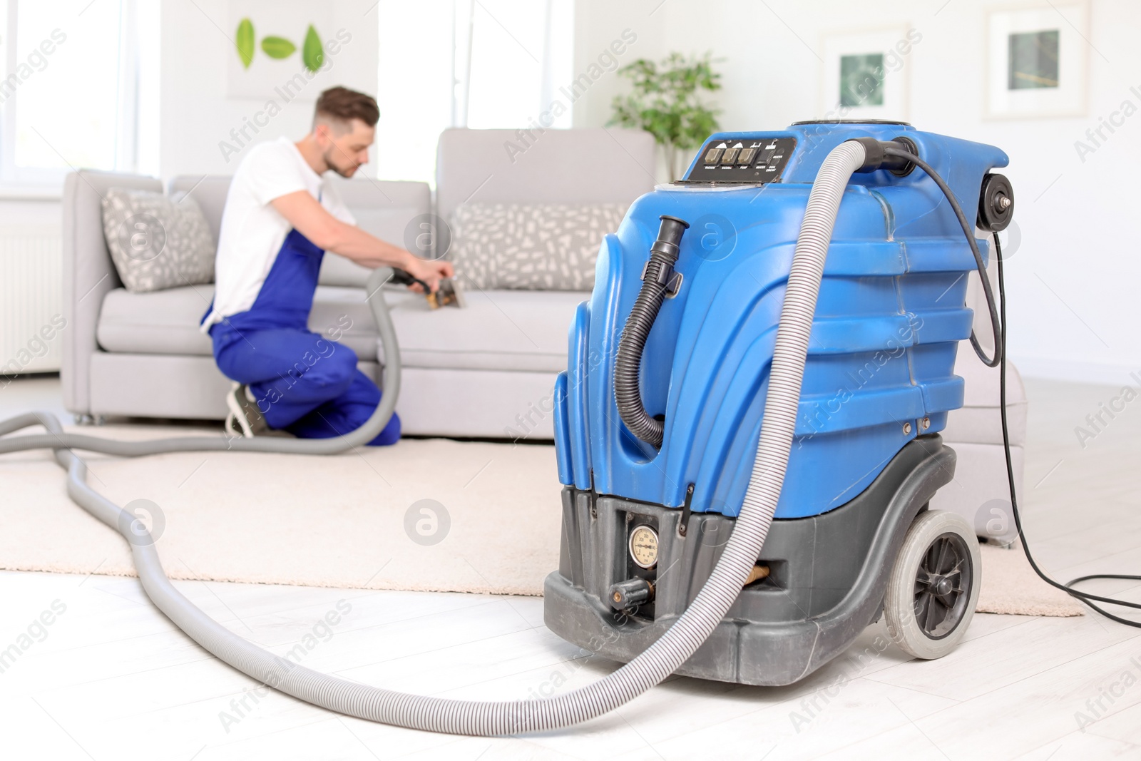 Photo of Dry cleaning machine and male worker on background