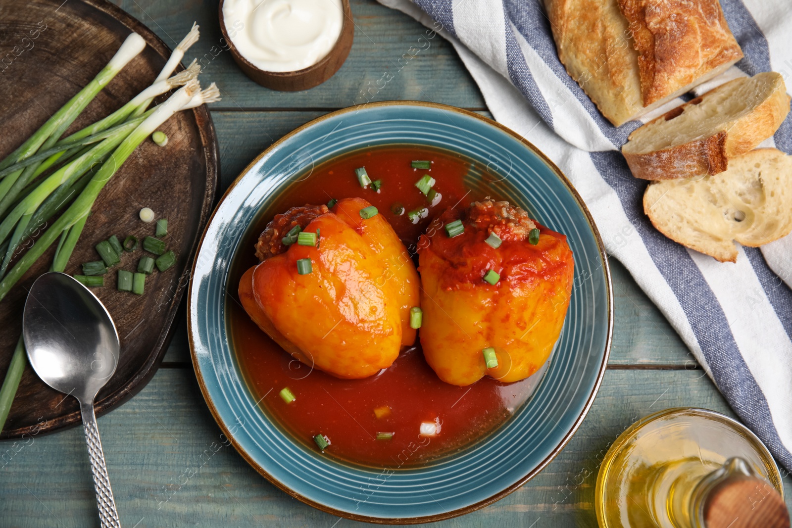 Photo of Delicious stuffed peppers served on blue wooden table, flat lay