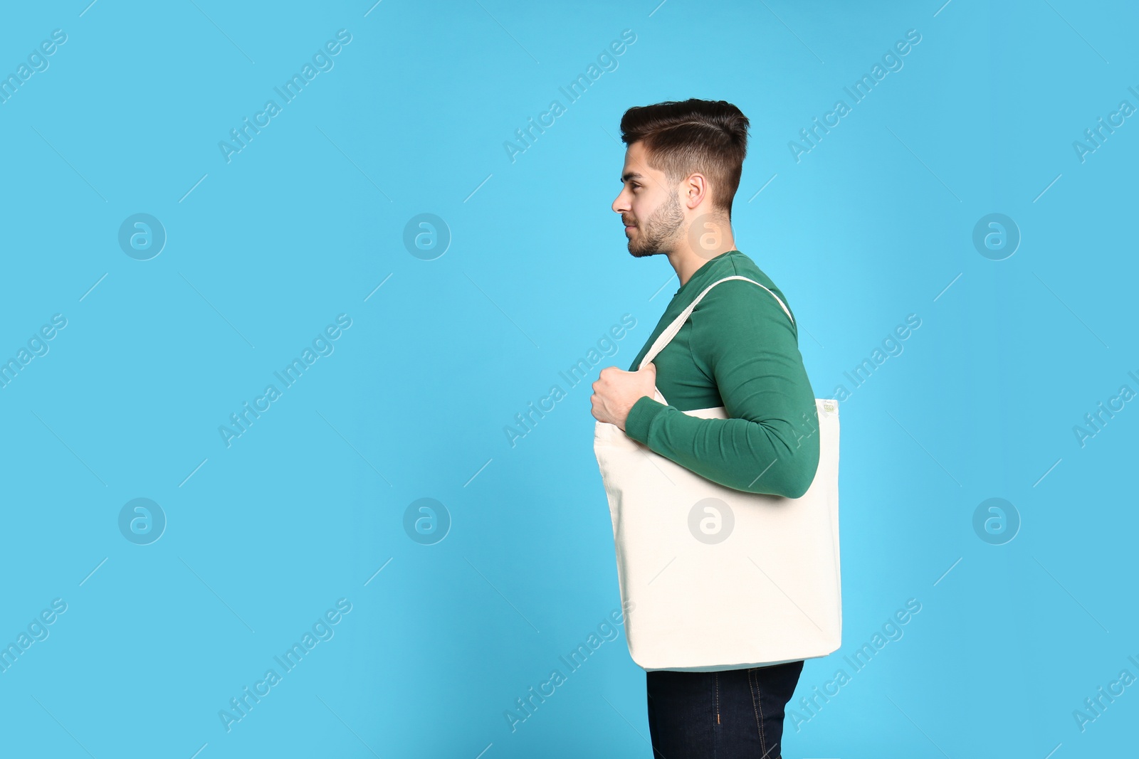 Photo of Portrait of young man with eco bag on blue background. Space for text