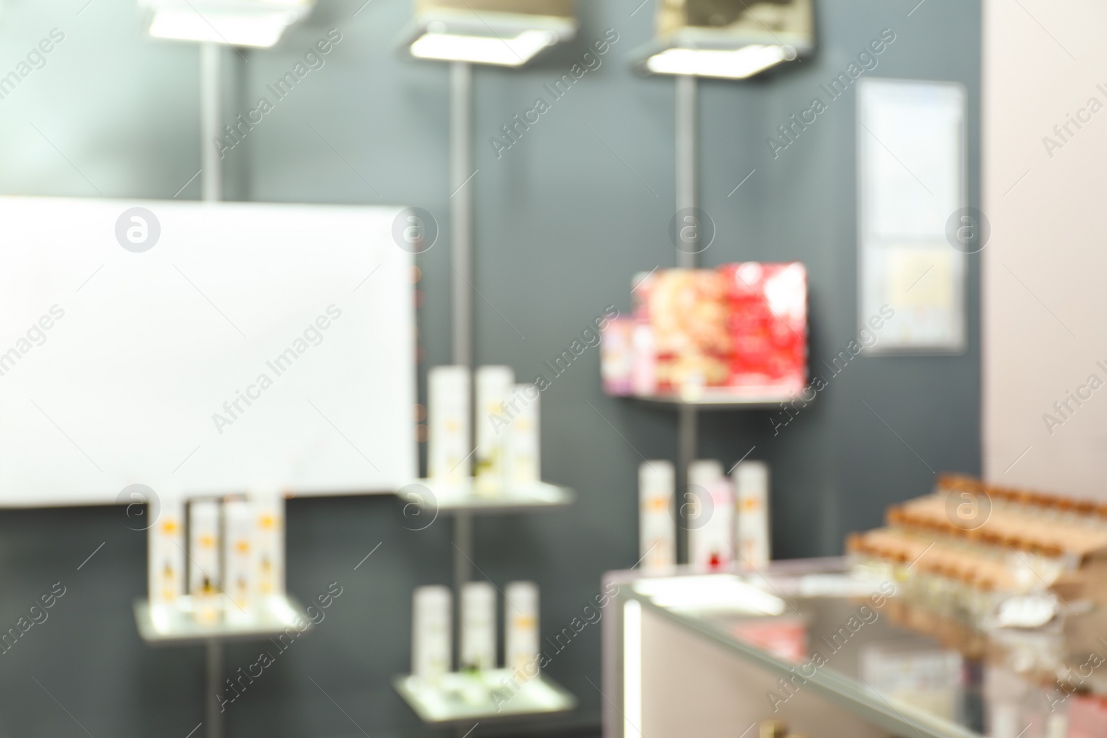 Photo of Blurred view of shelves with perfume bottles in shop