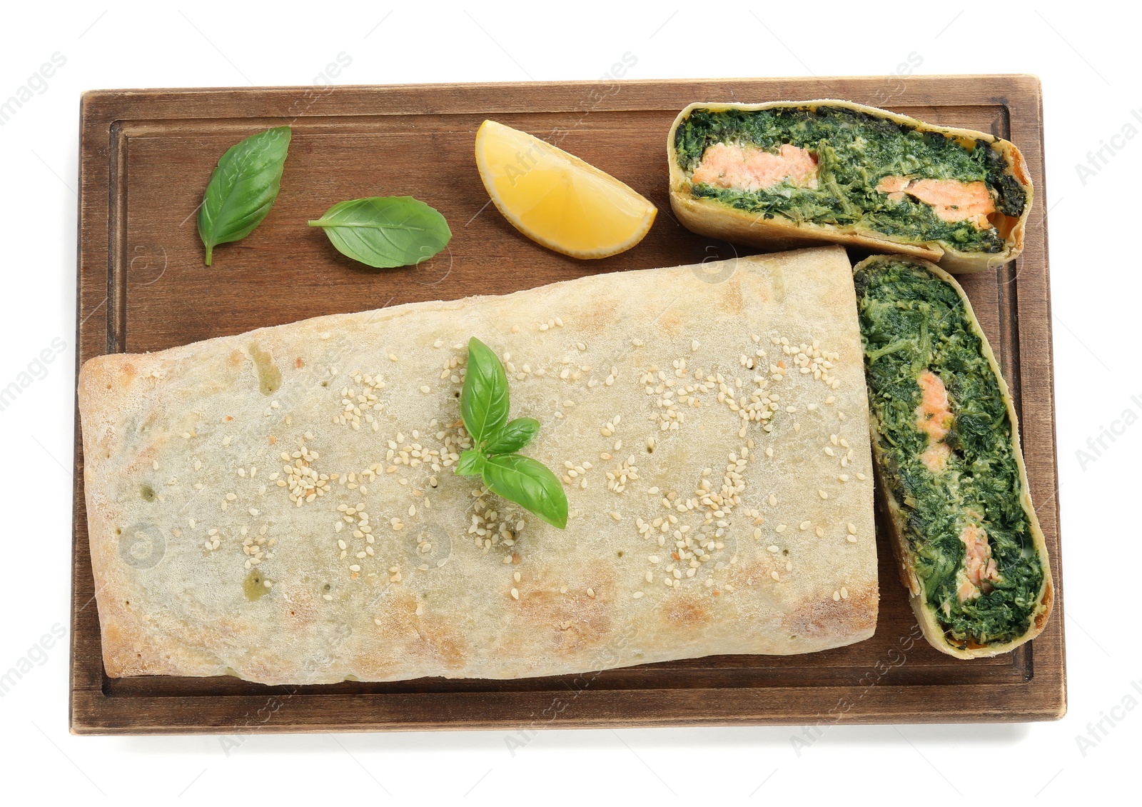 Photo of Cut tasty strudel with salmon, spinach, basil and lemon isolated on white, top view