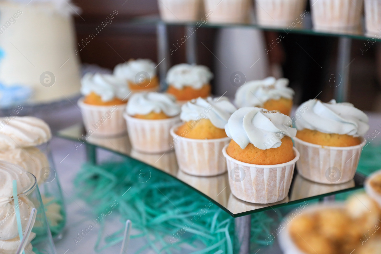 Photo of Delicious cupcakes with cream on dessert stand, closeup