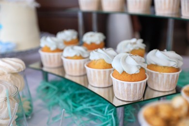 Photo of Delicious cupcakes with cream on dessert stand, closeup