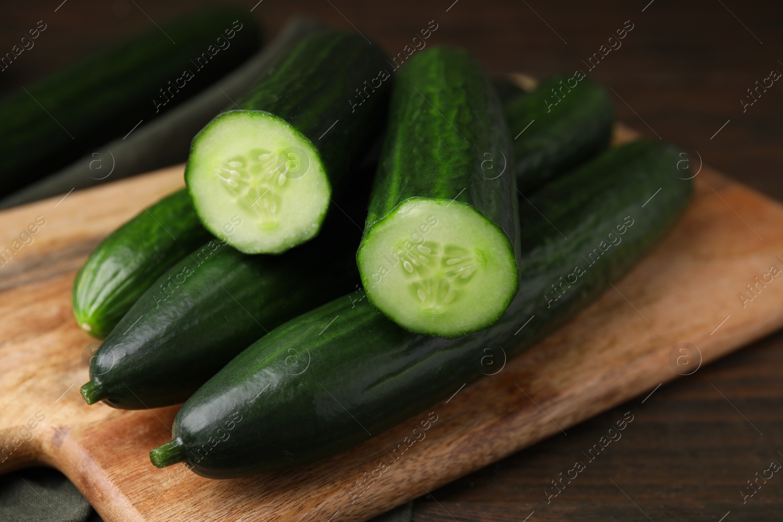 Photo of Many fresh cucumbers on wooden table, closeup