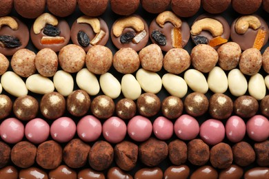 Different delicious chocolate candies as background, closeup