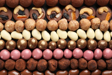 Photo of Different delicious chocolate candies as background, closeup