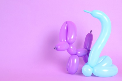 Photo of Animal figures made of modelling balloons on color background. Space for text
