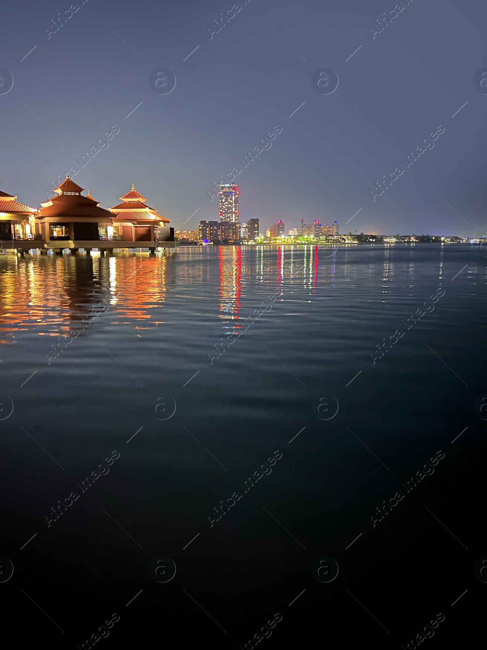 Photo of Picturesque view of sea and illuminated city at night