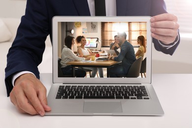 Image of Businessman attending online video conference via modern laptop at table in office, closeup