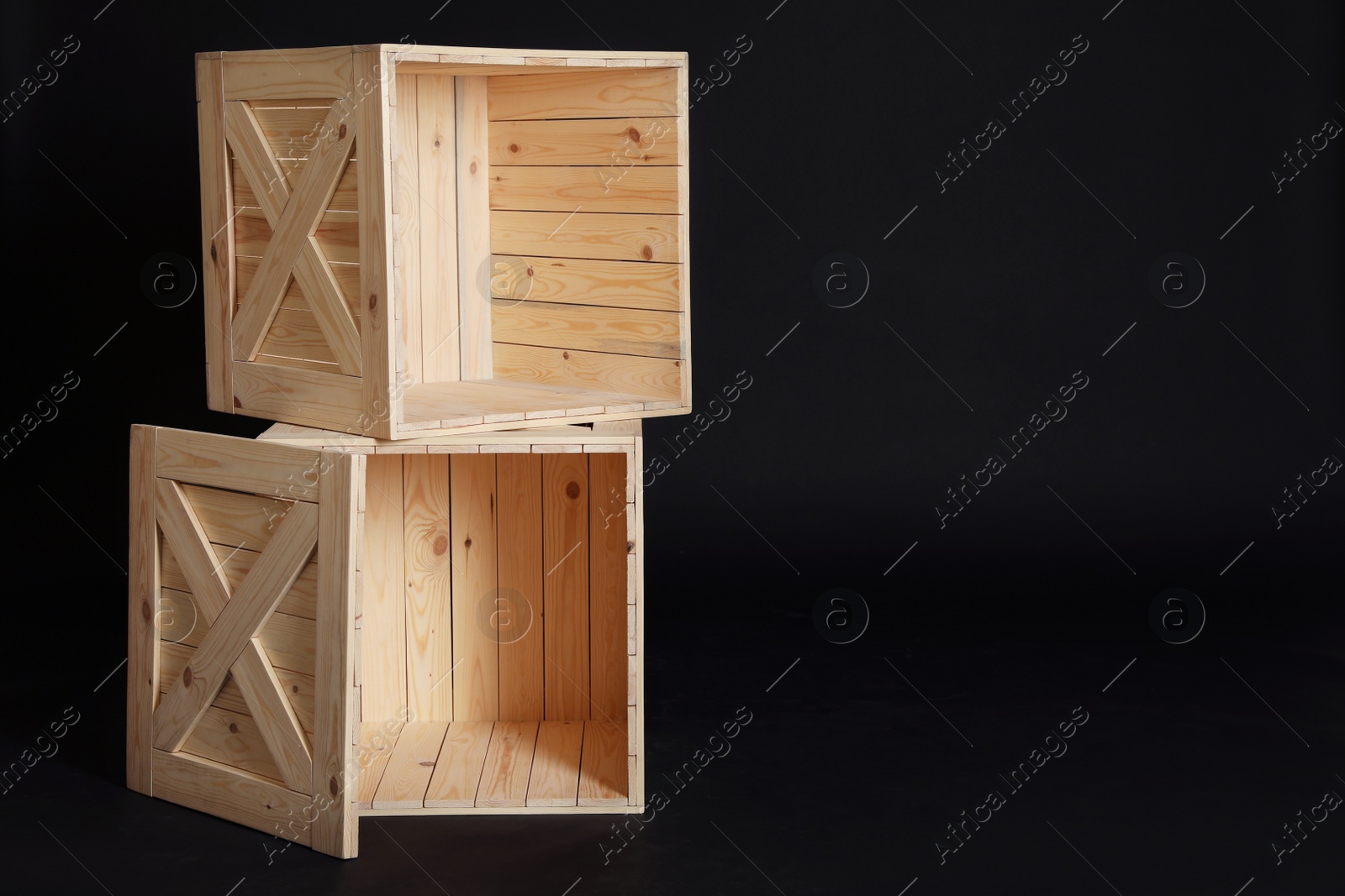 Photo of Wooden crates on black background. Space for text