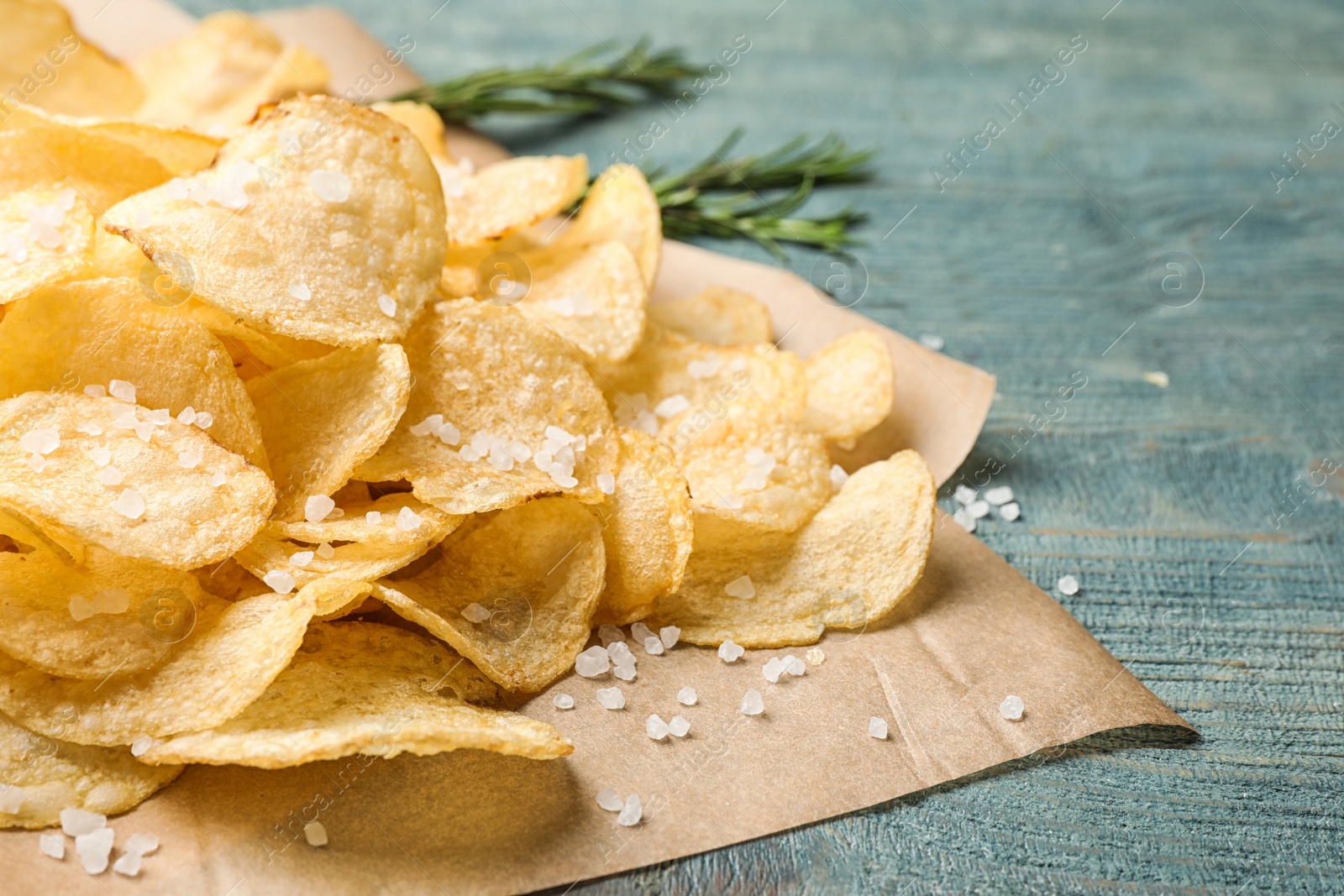 Photo of Delicious crispy potato chips on table, closeup with space for text