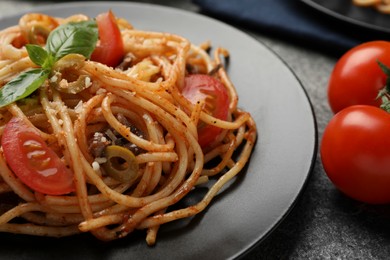 Photo of Delicious pasta with anchovies, tomatoes and olives on table, closeup