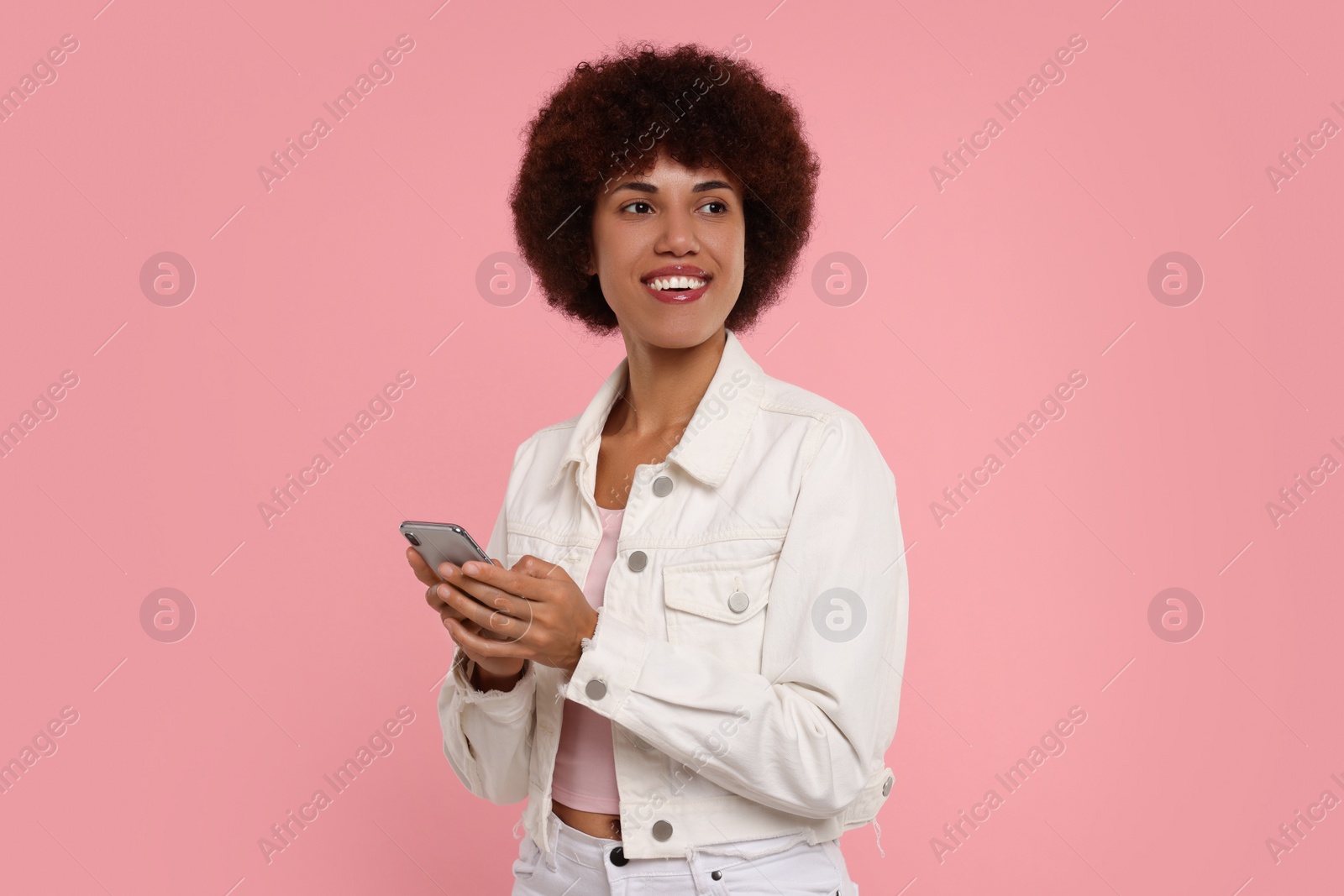 Photo of Happy young woman with smartphone on pink background