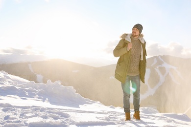 Man spending winter vacation in mountains. Space for text