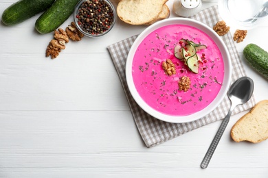Photo of Delicious cold summer beet soup on white wooden table, flat lay. Space for text