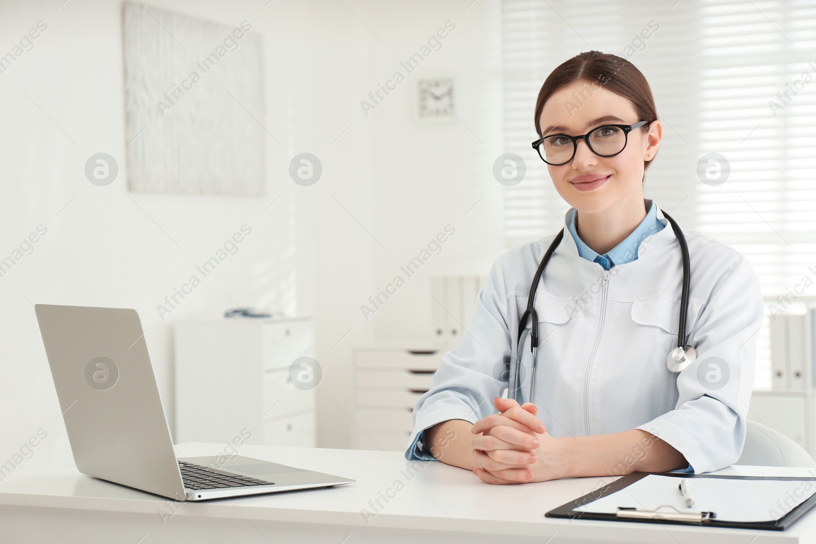 Photo of Portrait of young female doctor in white coat at workplace