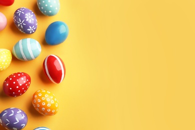 Flat lay composition of painted Easter eggs on color background, space for text