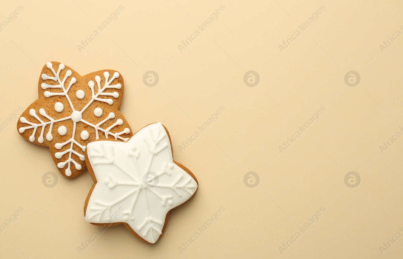 Photo of Tasty Christmas cookies with icing on beige background, flat lay. Space for text